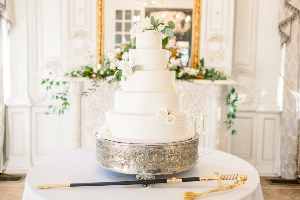 A 5-tiered wedding cake in the ballroom.